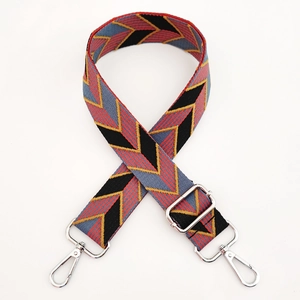 Detail of colorful geometric leaf pattern woven bag strap with silver metal lobster clasps