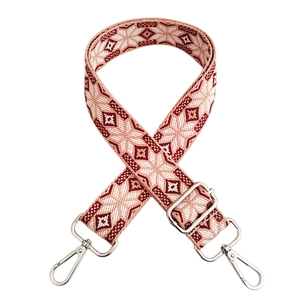 Detail of red and cream geometric woven bag strap with silver metal swivel hooks