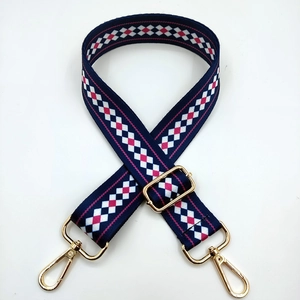 Close-up of adjustable ethnic style strap with pink and blue diamond patterns and gold hooks