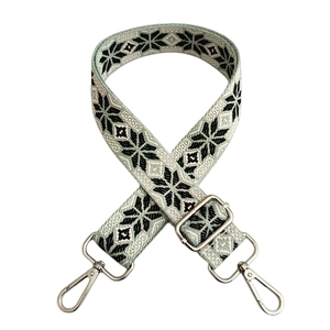 Detail of green geometric snowflake woven strap with silver swivel lobster clasps