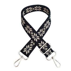 Detail of ethnic embroidered wide bag strap with silver metal lobster clasps and buckles