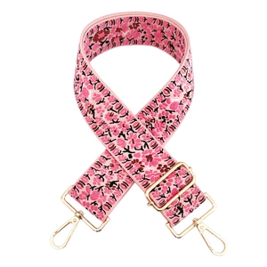 Detail of floral embroidered pink wide bag strap with gold lobster clasps and metal buckle