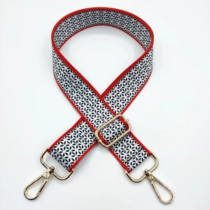 Detail of adjustable wide canvas shoulder strap with geometric stars and gold hardware