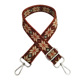 Close-up of orange geometric woven shoulder strap with shiny silver metal hooks