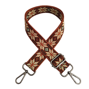 Detail of adjustable geometric snowflake woven strap with silver metal swivel hooks