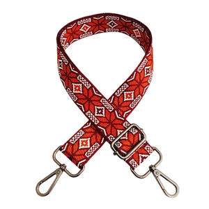 Ethnic style embroidered shoulder strap with red and white geometric patterns and silver clips