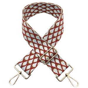 Close-up of red and blue peacock jacquard guitar strap with golden metal lobster clasps
