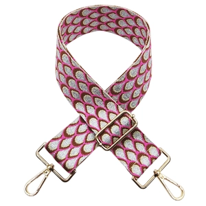 Detail of colorful jacquard wide strap with peacock pattern and gold lobster clasp