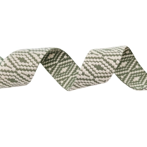 Détail de la texture du motif géométrique de losanges vert et blanc sur la bandoulière