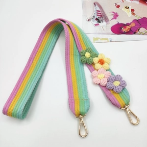Detail of crochet rainbow bag strap with colorful handmade flowers and gold metal clips