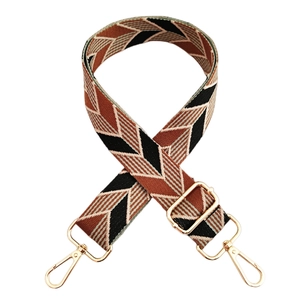 Detail of widened ethnic canvas bag strap with golden metal lobster clasps and buckles