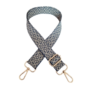Close-up of geometric diamond jacquard strap with gold-tone metal buckles and navy pattern