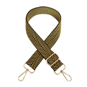 Close-up of woven herringbone bag strap with gold metal hooks and adjustable buckle
