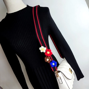 Detail of adjustable woven strap with handmade knit flowers and gold metal clasps