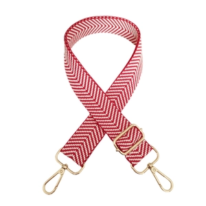 Detail of red and white wave pattern jacquard bag strap with gold metal buckles