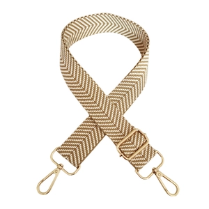 Detail of adjustable beige chevron canvas bag strap with golden metal swivel hooks