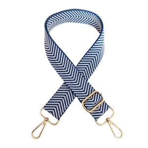 Detail of blue and white herringbone wide bag strap with gold metal hooks and buckle