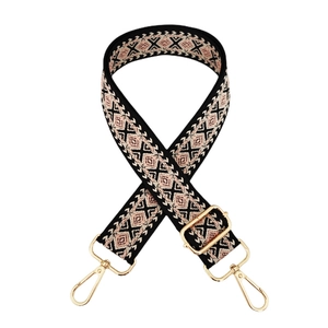 Close-up of geometric jacquard wide bag strap with gold metal lobster clasps