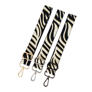 Adjustable zebra print bag strap with three metal hardware finish options in gold and silver