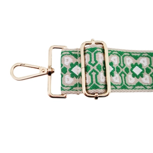Detail of bohemian embroidery purse strap with green geometric patterns and gold clips