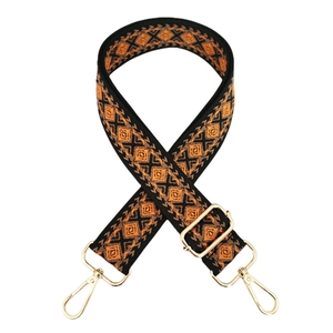 Detail of bohemian geometric rhombus pattern woven strap with gold metal buckles