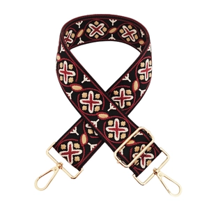 Close-up of ethnic jacquard wide shoulder strap with red floral embroidery and gold hooks