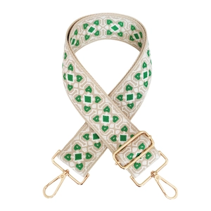 Close-up of wide jacquard bag strap with green geometric pattern and gold hardware