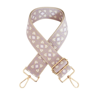 Macro shot of geometric jacquard bag strap with gold metal hooks and buckle