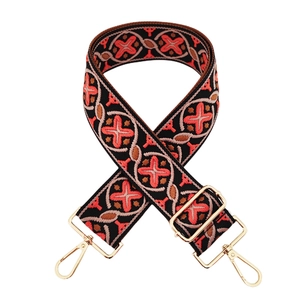 Detail of colorful jacquard wide bag strap with ethnic geometric patterns and gold clips