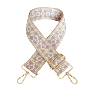 Detail of purple geometric jacquard woven strap with adjustable gold metal hardware buckles