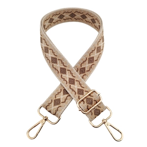 Close-up of geometric diamond pattern woven bag strap with gold metal lobster clasps