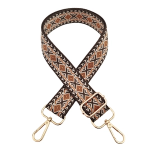 Close-up of geometric diamond pattern weaving and gold hardware on wide bag strap