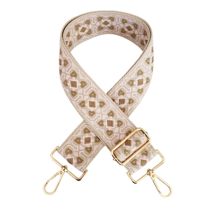 Detail of bohemian jacquard bag strap with pink geometric weaving and gold metal hooks