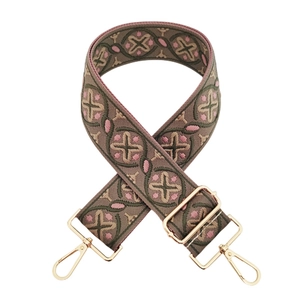 Close-up of thick jacquard woven strap with floral pattern and gold metal hooks
