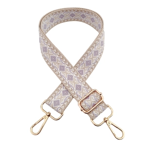 Detail of colorful geometric diamond pattern bag strap with gold metal hooks