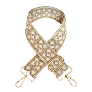 Close-up of geometric jacquard wide strap with golden metal lobster clasps and slider