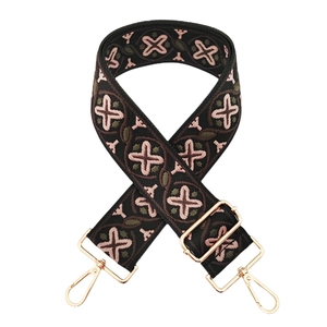 Detail of floral embroidery on wide crossbody strap with gold metal lobster clasps