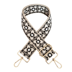 Detail of colorful jacquard guitar strap with vintage geometric patterns and gold lobster clasps