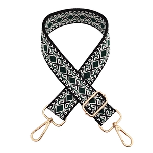 Close-up of geometric diamond pattern woven strap with polished gold metal buckles