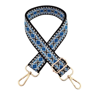 Detail of adjustable blue geometric diamond woven shoulder strap with gold metal buckles