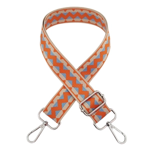 Detail of 3.8cm wide woven bag strap with orange and blue wave pattern and silver hooks