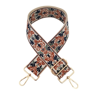Detail of vintage jacquard embroidery bag strap with golden metal lobster clasps