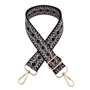 Close-up of geometric diamond weave bag strap with pale gold metal swivel hooks