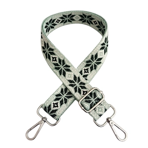 Close-up of ethnic style embroidered bag strap with silver metal swivel hooks and buckle