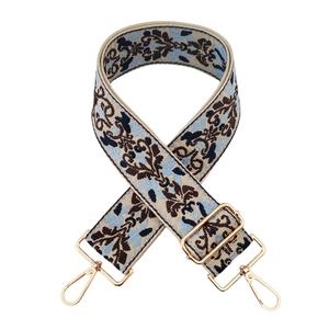Macro shot of ethnic vintage floral jacquard bag strap with golden metal swivel hooks