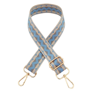 Detail of colorful wave pattern woven bag strap with adjustable gold metal hardware