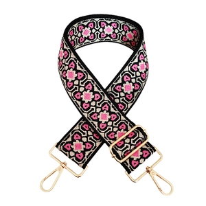 Detail of colorful geometric jacquard wide shoulder strap with gold metal hooks and buckle