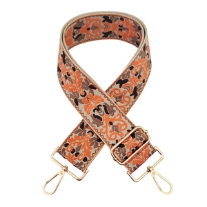 Close-up of vintage floral jacquard wide bag strap with gold metal lobster clasps