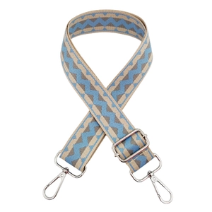 Detail of blue and beige zigzag weave bag strap with silver metal lobster clasps