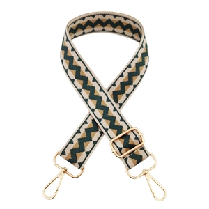 Close-up of wide woven bag strap with vintage wave jacquard and gold metal buckles